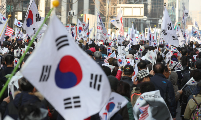 Supporters of former President Park Geun-hye stage a parade in downtown Seoul on Saturday in protest against the Constitutional Court's decision to expel her a day ago. (Yonhap)