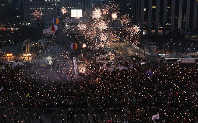 South Koreans celebrate the impeachment of former President Park Geun-hye during a rally in central Seoul on Saturday. (Yonhap)