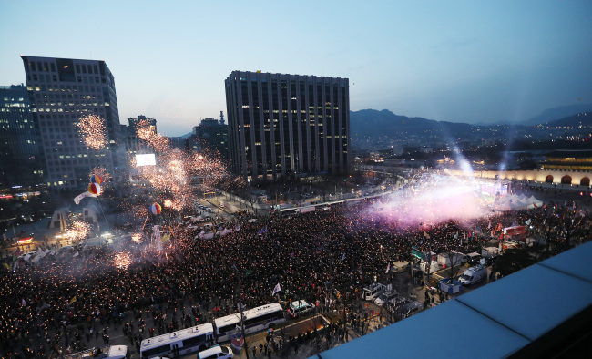 South Koreans celebrate the impeachment of former President Park Geun-hye during a rally in central Seoul on Saturday. (Yonhap)