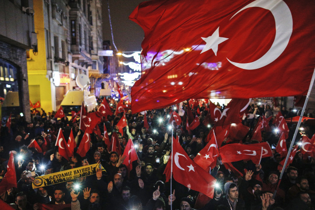 <YONHAP PHOTO-1259> Protesters wave flags outside the Dutch consulate in central Istanbul's Istiklal Avenue, the main shopping road of Istanbul, early Sunday, March 12, 2017. The escalating dispute between Turkey and the Netherlands spilled over into Sunday, with a Turkish minister unable to enter her consulate after the authorities there had already blocked a visit by the foreign minister, prompting Turkish President Recep Tayyip Erdogan to call the Dutch fascists. (AP Photo/Emrah Gurel)/2017-03-12 10:33:12/ <저작권자 ⓒ 1980-2017 ㈜연합뉴스. 무단 전재 재배포 금지.>
<YONHAP PHOTO-1259> Protesters wave flags outside the Dutch consulate in central Istanbul's Istiklal Avenue, the main shopping road of Istanbul, early Sunday, March 12, 2017. The escalating dispute between Turkey and the Netherlands spilled over into Sunday, with a Turkish minister unable to enter her consulate after the authorities there had already blocked a visit by the foreign minister, prompting Turkish President Recep Tayyip Erdogan to call the Dutch fascists. (AP Photo/Emrah Gurel)/2017-03-12 10:33:12/ <저작권자 ⓒ 1980-2017 ㈜연합뉴스. 무단 전재 재배포 금지.>