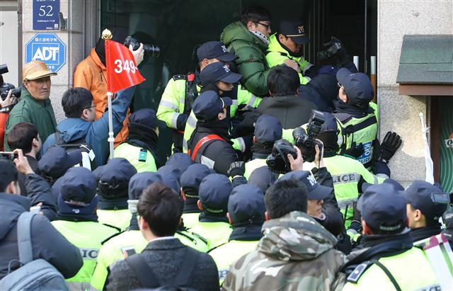 ‘박 전 대통령 지키기’에 나선 탄핵반대 단체 회원들이 13일 오전 서울 강남구 삼성동 박근혜 전 대통령 사저 앞에서 취재를 위해 인근 건물 옥상으로 올라가려는 취재진을 막아서며 뒤엉켜 있다. 연합뉴스