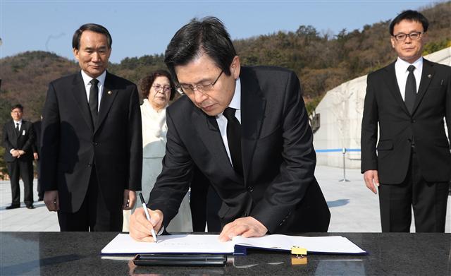 황교안 대통령 권한대행 국무총리가 15일 오전 경남 창원시 마산회원구 국립 3·15 민주묘지를 참배한 뒤 방명록을 작성하고 있다. [연합뉴스]