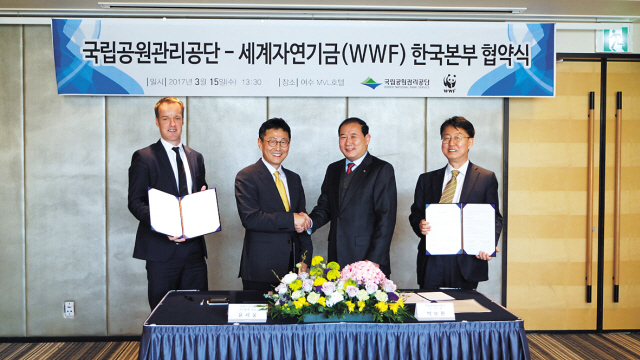 윤세웅 WWF 한국본부 대표(왼쪽 두번째)와 박보환 국립공원관리공단 이사장이 15일 업무협약서에 서명한 뒤 악수하고 있다. [사진제공=WWF]