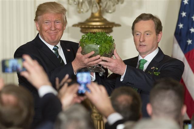 <YONHAP PHOTO-1473> US President Donald Trump receives a traditional bowl of shamrocks from Taoiseach of Ireland Enda Kenny (R) during a St. Patrick?s Day Reception in the East Room of the White House in Washington, DC, March 16, 2017. / AFP PHOTO / SAUL LOEB/2017-03-17 07:40:55/ <저작권자 ⓒ 1980-2017 ㈜연합뉴스. 무단 전재 재배포 금지.>