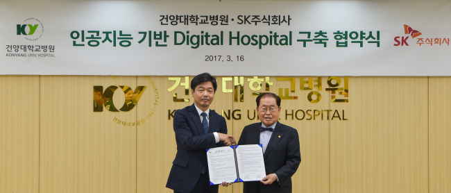 General Manager of SK C&C's IT service division Lee Ki-yeol (left) and Konyang University President Kim Hee-soo pose after signing an agreement to bring IBM's Watson for Oncology to the hospital and to digitize the hospital's administrative services, Thursday. The MOU signing ceremony was held at the hospital located in Dajeon. (SK C&C)
