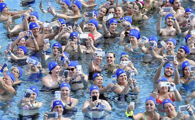 <YONHAP PHOTO-1363> epa05858293 Participants attempt to set a new Hungarian record of the most people taking a selfie in water simultaneously in an outdoor pool of Szechenyi Thermal Bath and Swimming Pool in Budapest, Hungary, 19 March 2017. The group of 113 people, including the Hungarian synchronized swimming team and volunteer organizers of the 17th FINA Aquatics World Championships, succeeded in setting the new record to mark the 117th day before the start of tournament hosted by Budapest and Balatonfured from July 14 to 30. EPA/Tibor Illyes HUNGARY OUT/2017-03-20 07:02:23/ <저작권자 ⓒ 1980-2017 ㈜연합뉴스. 무단 전재 재배포 금지.>