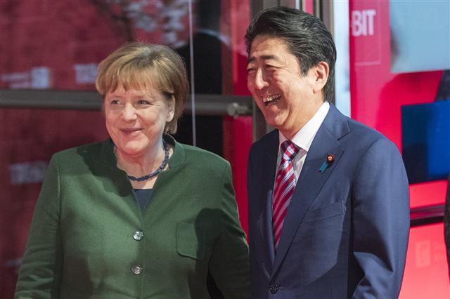 <YONHAP PHOTO-1015> epa05858664 Japanese Prime Minister Shinzo Abe (R) and German Chancellor Angela Merkel (L) share a light moment bas they arrive for the 'Welcome Night' opening event at the CeBIT computing trade fair in Hanover, northern Germany, 19 March 2017. Reports state that more than 3.000 exhibitors from 70 countries are showing their products and solutions at the fair which expects to see about 200.000 visitors from 20 to 24 March 2017. Japan is this year's partner country of the CeBIT. EPA/CARSTEN KOALL/2017-03-20 06:08:26/ <저작권자 ⓒ 1980-2017 ㈜연합뉴스. 무단 전재 재배포 금지.>