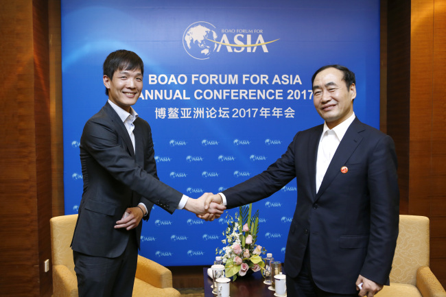 　Kim Dong-won (left), managing director of Hanwha Life Insurance shakes hands with Zhao Haishan, vice mayor of Tianjin, China, at a meeting held during Boao Forum for Asia on Friday.
(Hanwha Group)
