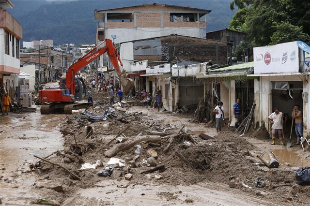 <YONHAP PHOTO-0884> A backhoe removes debris and mud from a street in Mocoa, Colombia, Sunday, April 2, 2017. Colombia's President Juan Manuel Santos, who has declared Mocoa a disaster area, said that at least 207 were killed but that the death toll was changing "every moment." Authorities said another 200 people, many of them children, were injured and just as many were unaccounted for amid the destruction. (AP Photo/Fernando Vergara)/2017-04-03 05:55:28/ <저작권자 ⓒ 1980-2017 ㈜연합뉴스. 무단 전재 재배포 금지.>