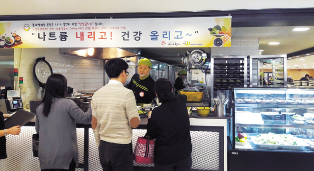 롯데백화점 직원들이 건강식 코너에서 음식을 받고 있다.
