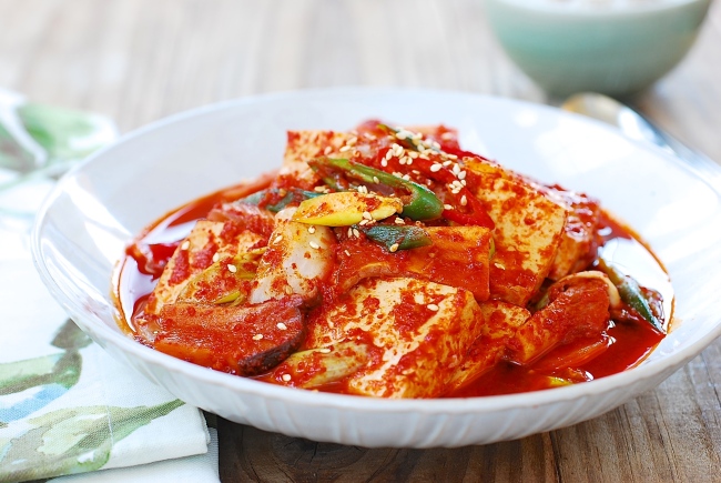 Korean dubu jorim, braised tofu slices in spicy soy sauce with scallions, peppers, and sesame seeds