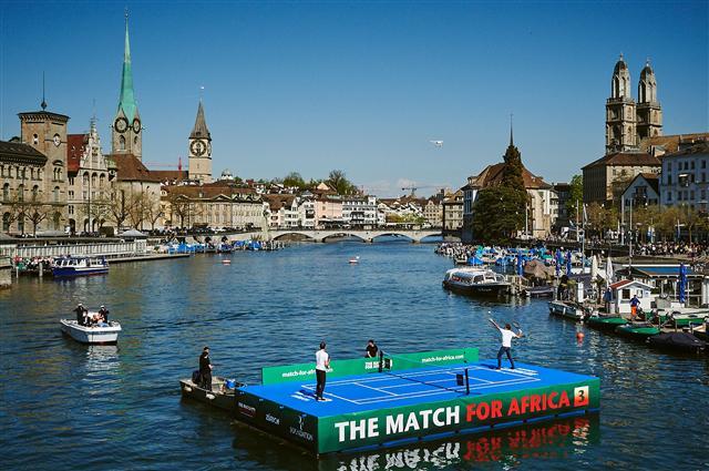 <YONHAP PHOTO-4802> Swiss tennis superstar Roger Federer (R) serves a ball to world number one Britain's Andy Murray during a promotion on a raft on the river Limmat before a charity tennis match on April 10, 2017 in Zurich. "The Match for Africa 3", is the third charity tennis event for the Roger Federer Foundation, that provides funding to children living in poverty to help them realize their potential and also supports education projects in seven countries in southern Africa as well as Switzerland. / AFP PHOTO / Michael Buholzer/2017-04-10 20:12:17/ <저작권자 ⓒ 1980-2017 ㈜연합뉴스. 무단 전재 재배포 금지.>