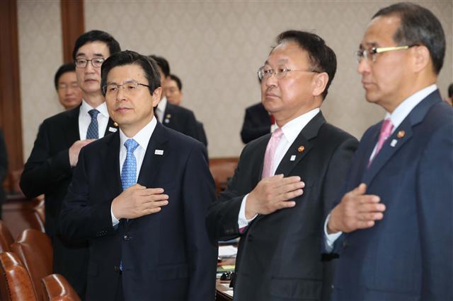 전쟁 임박설 등 한반도의 지정학적 불안이 최고조에 달하면서 국가적 위기관리가 시험대에 오른 가운데 황교안 대통령 권한대행을 비롯한 국무위원들이 11일 서울 세종로 정부서울청사에서 열린 국무회의에서 국기에 대한 경례를 하고 있다.  [연합뉴스]
