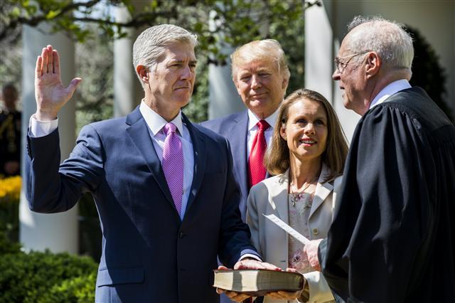 <YONHAP PHOTO-0179> epa05901570 Justice Anthony M. Kennedy (R) administers the judicial oath to the US Supreme Court's newest member, Neil M. Gorsuch (L), while US President Donald J. Trump (C-L) and Gorsuch's wife Louise (C-R) look on in the Rose Garden of the White House in Washington, DC, USA, 10 April 2017. The Senate confirmed Judge Gorsuch on 07 April after a 14-month battle to replace the seat vacated by the death of Judge Antonin Scalia. EPA/JIM LO SCALZO/2017-04-11 00:53:42/ <저작권자 ⓒ 1980-2017 ㈜연합뉴스. 무단 전재 재배포 금지.>