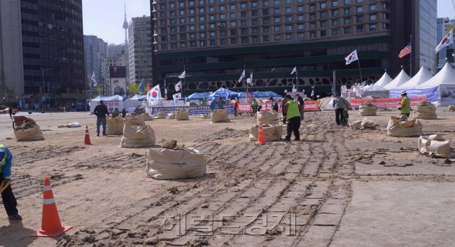 보수단체의 텐트 무단 점거로 무기한 연기됐던 서울 시청 앞 광장 잔디 식재 작업이 12일부터 시작되었다.  <br />서울시는 시민 모두를 위한 서울 광장을 더 이상 황량한 상태로 둘 수 없다고 판단, 보수단체가 불법점유한 부분은 제외하고  잔디 식재 작업에 들어갔다.<br /> 현재 서울광장은 ‘대통령 탄핵무효 국민저항 총궐기 운동본부(탄무국)’ 등 보수단체가 서울시 사전승인 없이 지난 1월 21일부터 광장 중앙에 대형텐트 41개 동을 설치한 채 시위를 벌이고 있다. 이들은 대통령 탄핵기각을 주장하며 시위를 시작, 지난달 10일 헌법재판소의 박근혜 전 대통령 탄핵 인용 후에도 탄핵 무효를 주장하며 불법점유를 이어가고 있다. <br />이 때문에 애초 3월 1일부터 4월 15일까지 마무리하기로 했던 서울광장 잔디 식재작업은 무기한 연기돼 서울 광장 푸른 잔디를 언제 볼 수 있을지 불투명한 상황이었다.<br />정희조 기자/chehco@heraldcorp.com  170412
보수단체의 텐트 무단 점거로 무기한 연기됐던 서울 시청 앞 광장 잔디 식재 작업이 12일부터 시작되었다.
서울시는 시민 모두를 위한 서울 광장을 더 이상 황량한 상태로 둘 수 없다고 판단, 보수단체가 불법점유한 부분은 제외하고  잔디 식재 작업에 들어갔다.
현재 서울광장은 ‘대통령 탄핵무효 국민저항 총궐기 운동본부(탄무국)’ 등 보수단체가 서울시 사전승인 없이 지난 1월 21일부터 광장 중앙에 대형텐트 41개 동을 설치한 채 시위를 벌이고 있다. 이들은 대통령 탄핵기각을 주장하며 시위를 시작, 지난달 10일 헌법재판소의 박근혜 전 대통령 탄핵 인용 후에도 탄핵 무효를 주장하며 불법점유를 이어가고 있다.
이 때문에 애초 3월 1일부터 4월 15일까지 마무리하기로 했던 서울광장 잔디 식재작업은 무기한 연기돼 서울 광장 푸른 잔디를 언제 볼 수 있을지 불투명한 상황이었다.
정희조 기자/chehco@heraldcorp.com  170412