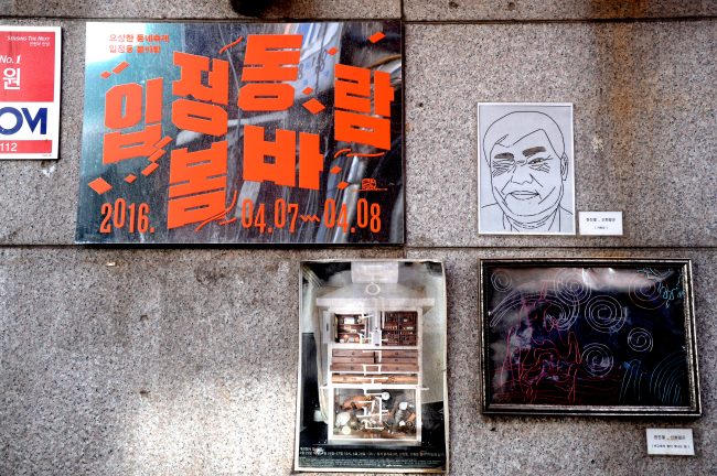 Pieces of art by local artists and a poster for an art festival hang on the wall at the workshop alley in Euljiro, Jung-gu, in Seoul, April 12. (Park Hyun-koo/The Korea Herald)