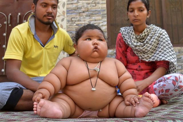 <YONHAP PHOTO-4030> Indian parents Suraj (L) and Reenu (R) pose for a photograph with their daughter Chahat (C) at their home in Amritsar on April 17, 2017. Chahat, who is eight months old, reportedly weighs more than 17 kgs. / AFP PHOTO / NARINDER NANU/2017-04-17 23:13:06/ <저작권자 ⓒ 1980-2017 ㈜연합뉴스. 무단 전재 재배포 금지.>