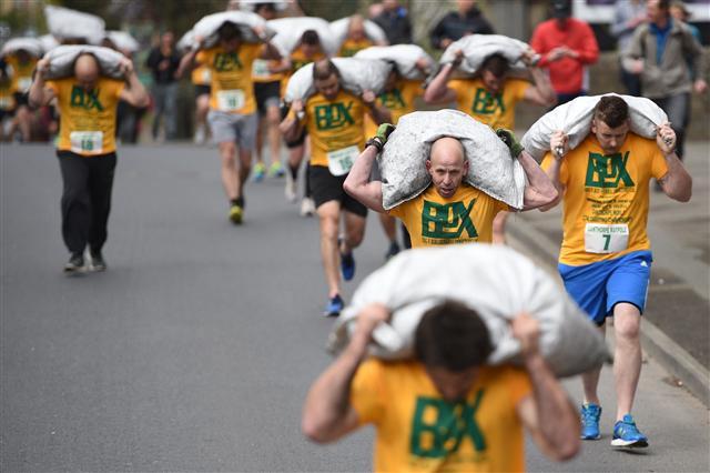 <YONHAP PHOTO-3897> Competitors take part in the Men's Race at the annual World Coal Carrying Championships in the village of Gawthorpe, near Wakefield, northern England on April 17, 2017. The World Coal Carrying Championships, which began in 1963, takes place on Easter Monday and challenges participants to race with a sack of coal for just over one kilometre to secure the best time. The event features Men's, Women's and Children's races with Men carrying 50kg of coal and women 20kg in weight. To finish the sack of coal must be dropped on the Village Green where the traditional Maypole is situated in the heart of Gawthorpe. / AFP PHOTO / OLI SCARFF/2017-04-17 22:07:55/ <저작권자 ⓒ 1980-2017 ㈜연합뉴스. 무단 전재 재배포 금지.>