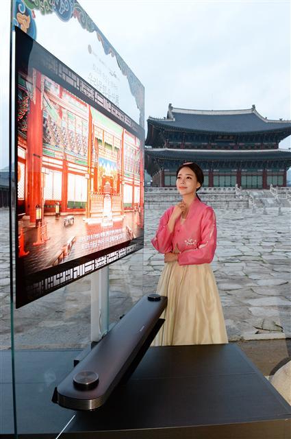 LG전자는 문화재청과 함께 경복궁에서 ‘최고의 작품을 만나다. 우리 문화유산전’을 진행한다고 20일 전했다. LG전자는 지난 19일부터 내달 7일까지 열리는 이번 전시회를 위해 ‘LG 시그니처 올레드 TV W’를 비롯한 올레드 TV 15대를 경복궁 곳곳에 설치했다. 사진은 LG전자 모델이 경복궁에 설치된 ‘LG 시그니처 올레드 TV W’ 옆에서 포즈를 취한 모습.  [사진제공=LG전자]