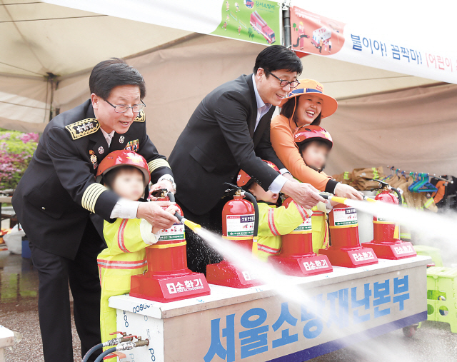 한화손해보험 박윤식 대표(오른쪽에서 두번째)와 권순경 소방재난본부장이 안전체험한마당에 참여한 어린이들과 소화기 사용방법에 대한 교육을 하고 있다.