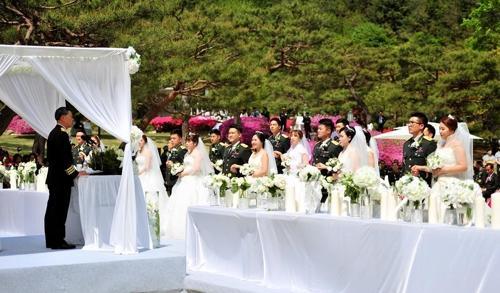 충남 계룡대 육군참모총장 공관 앞 정원에서 열린 합동결혼식에서 신랑신부들이 장준규 육군참모총장의 주례사를 듣고 있다.
