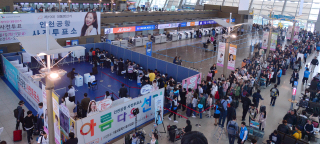사상 첫 대통령선거 사전투표가 시작된 4일 인천국제공항 3층에 마련된 사전투표소 앞은 투표소가 열리는 오전 6시 이전부터 소중한 한 표를 행사하려는 유권자들이 장사진을 이뤘다. 사진은 인천공항에 마련된 사전투표소에서 여행객들이 투표를 하는 모습. 사전투표는 주민등록증과 운전면허증 등 신분증이 있으면 주소지에 상관없이 전국 어느 사전투표소에서나 할 수 있다.  인천=이상섭 기자/babtong@