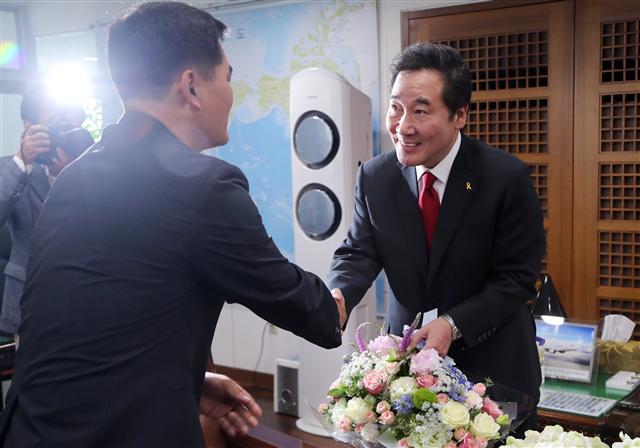 이낙연 국무총리 후보자가 11일 오전 전남 무안군 전남도청 집무실에서 전남도청 공무원노조위장으로부터 축하 꽃바구니를 받고 악수하고 있다. 	 [연합뉴스]