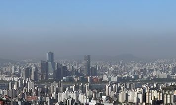 Seoul’s sky shows stark differences in colors as it is blanketed in a layer of fine dust and pollutants Monday. The fine dust level recorded average in Seoul on the day, the National Institute of Environmental Research said. (Yonhap)