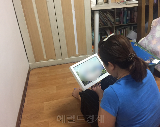 다문화가족이나 한부모 가정을 위한 각종 지원 제도가 생겨나고 있지만 공공주택제도 등 일부 정책에서는 다문화 한부모 가정이 뒷전으로 밀려나는 경우가 있는 것으로 나타났다. 가족 사진을 보고 있는 다문화 한부모 여성. [사진=이현정 기자/rene@heraldcorp.com]