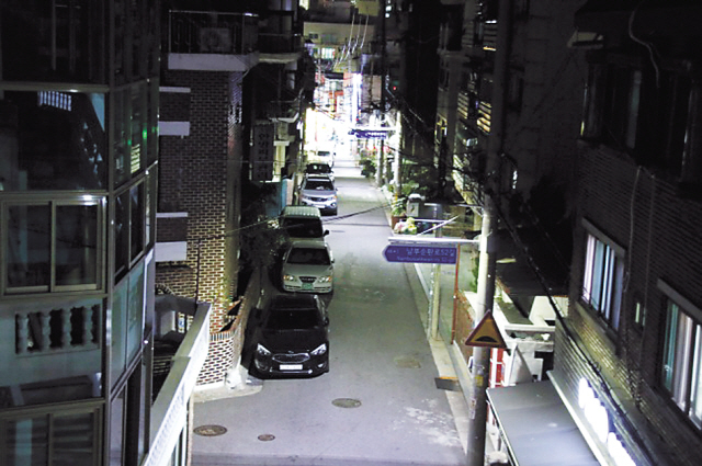 한 밤 중 가로등과 각종 광고물이 주택가를 훤히 비추고 있다.