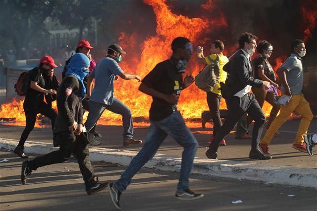 epa05987836 Demonstrators clash with police agents at the Ministeries Esplanade, in Brasilia, Brazil, 24 May 2017. The access to the Agriculture Ministry facilities was attacked with Molotov cocktails by protesters calling for Brazilian President Michel Temer resignation. EPA/Jo?son Alves