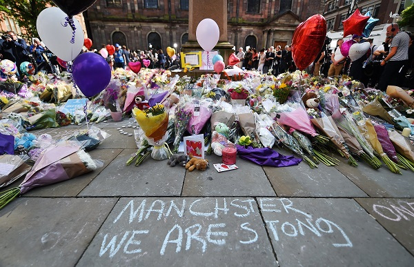 People look over floral tributes in St. Ann's Square for the people who lost their lives during the Manchester terror attack in central Manchester, Britain, 24 May 2017. (EPA-Yonhap)