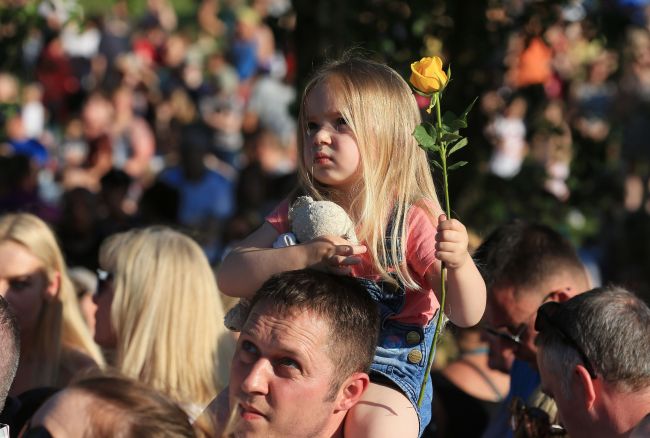 Three-year-old Ruby Tindall watches from her father Lee's shoulders during a vigil to commemorate the victims of the May 22 attack on Manchester Arena at Tandle Hill Country Park in Royton, northwest England, on May 26, 2017. (AFP-Yonhap)