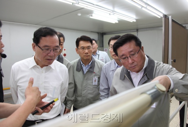 LG디스플레이 한상범 부회장과 동반성장위원회 안충영 위원장이 2015년 2차 협력사인 오성디스플레이를 방문해 생산현장을 둘러보고 있다.(사진 왼쪽 안충영 동반성장위원장, 사진 오른쪽 LG디스플레이 한상범 부회장)