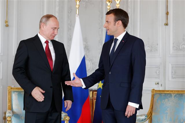 <YONHAP PHOTO-5332> epa05997367 French President Emmanuel Macron (R) offers to shakes hands with Russian President Vladimir Putin (L) at the Chateau de Versailles as they meet for talks before the opening of an exhibition marking 300 years of diplomatic ties between the two countyies in Versailles, France, 29 May 2017. Discussions are expected to include the situation in Syria and Russia's veto position at the UN security council. EPA/PHILIPPE WOJAZER / POOL MAXPPP OUT/2017-05-29 22:04:39/ <저작권자 ⓒ 1980-2017 ㈜연합뉴스. 무단 전재 재배포 금지.>