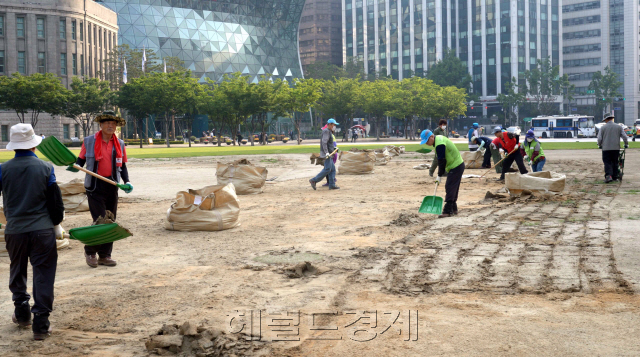 서울시 129일 동안 서울광장을 무단 점유해온 보수단체의 천막이 강제 철거됐다. 사진은 30일 오전 서울광장에서 서울시 직원들이 천막의 잔해를 치우고 새 잔디를 식재할 준비를 하고 있는 모습.  정희조 기자/checho@heraldcorp.com