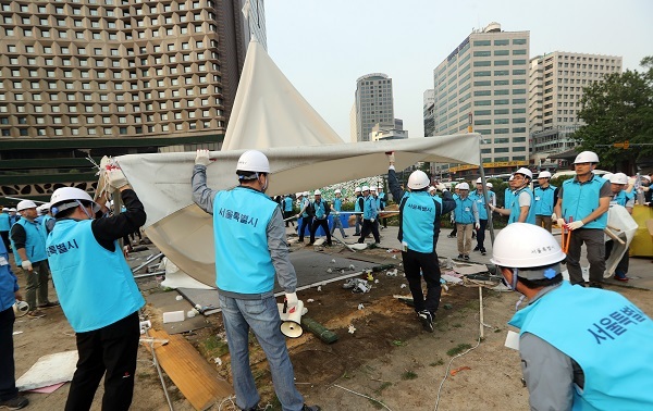 Seoul city officials remove the tents set up by supporters of former President Park Geun-hye at Seoul Plaza on Tuesday. The tents, installed on Jan. 21, have been occupying the plaza illegally for more than three months. (Yonhap)