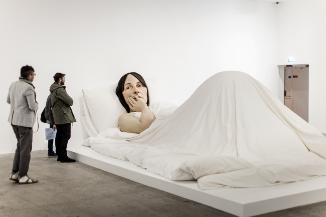 Ron Mueck, In Bed, 2005, mixed media, 162 x 650 x 395 cm, A/P, Collection of the Fondation Cartier pour l’art contemporain, Paris (acq. 2006), view of the exhibition Vivid Memories at the Fondation Cartier pour l'art contemporain, Paris, 2014 ⓒ Ron Mueck
, Photo ⓒ Thomas Salva / Lumento