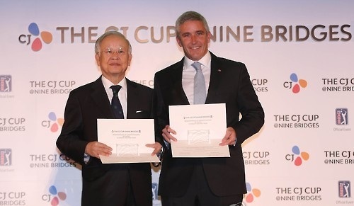 Sohn Kyung-shik, chairman of CJ Group (left), and Jay Monahan, then deputy commissioner of the PGA Tour, pose with their agreements in Seoul after CJ signed on to host the CJ Cup@Nine Bridges, the first PGA Tour event in South Korea on Oct. 24, 2016. (Yonhap)