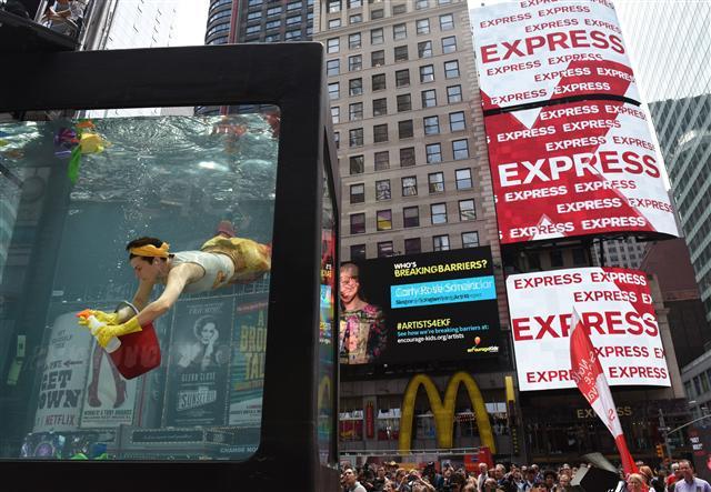 <YONHAP PHOTO-0522> Performance artist Annie Saunders performs " Cleaning" during a press preview from Holoscenes, a performance-installation in Times Square on May 31, 2017 in New York. The event is created by the artist Lars Jan and his company Early Morning Opera, that features a cast of performers in a twelve-ton, 8? x 6? x 10? glass aquarium and viscerally connects everyday actions to climate change. Times Square Arts and the World Science Festival are launching the event called Science in the Square, a four-day event that brings science?and climate science in particular. / AFP PHOTO / TIMOTHY A. CLARY / RESTRICTED TO EDITORIAL USE - MANDATORY MENTION OF THE ARTIST UPON PUBLICATION - TO ILLUSTRATE THE EVENT AS SPECIFIED IN THE CAPTION/2017-06-01 01:23:58/ <저작권자 ⓒ 1980-2017 ㈜연합뉴스. 무단 전재 재배포 금지.>