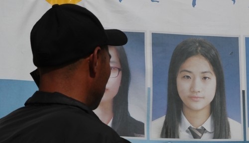 In this photo taken on May 19, 2017, the father of Sewol ferry victim Heo Da-yoon talks on the phone in front of his daughter's photo in Mokpo, some 410 kilometers south of Seoul. (Yonhap)