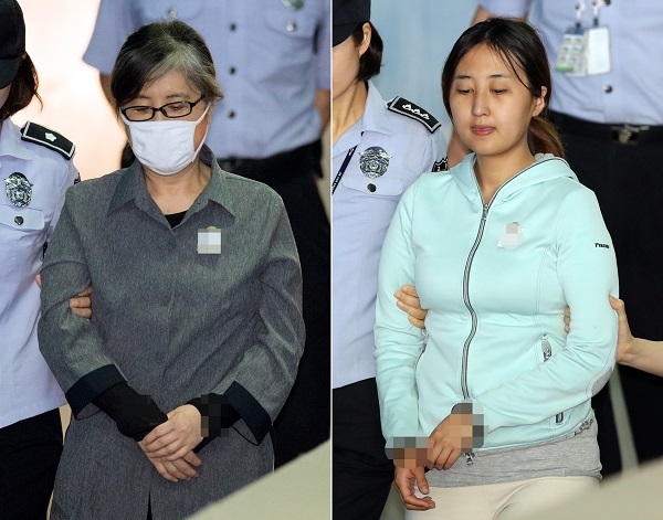 Chung Yoo-ra (right), daughter of ousted President Park Geun-hye’s friend Choi Soon-sil, heads to a courtroom at the Seoul Central District Court in southern Seoul to attend a hearing on her arrest warrant on Friday. Her mother Choi (left) also showed up at the court to stand her own trial. (Yonhap)