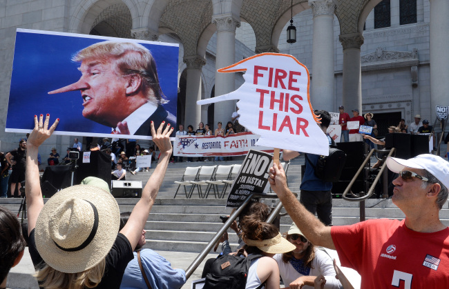 Demonstrators carrying placards march to City Hall through downtow in Los Angeles, Californian, Sautrday.   UPI-Yonhap