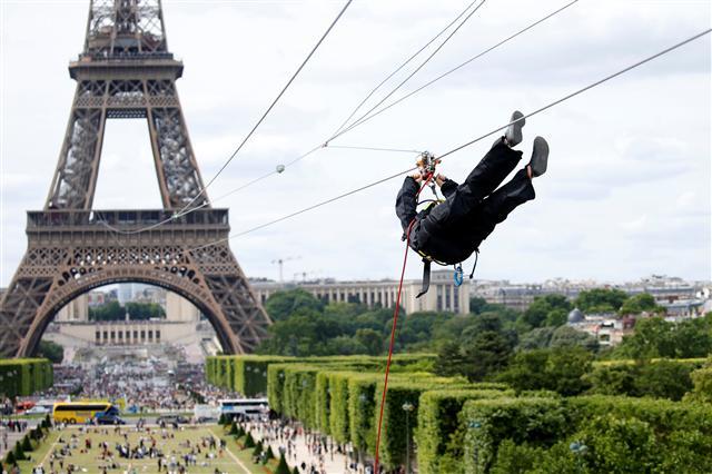 <YONHAP PHOTO-0127> A participant rides a zip line from the second floor of the Eiffel Tower, 115 metres above the ground along an 800-metre long route, as part of a free event operating until June 11 in Paris, France, June 4, 2017. REUTERS/Charles Platiau/2017-06-05 01:27:17/ <저작권자 ⓒ 1980-2017 ㈜연합뉴스. 무단 전재 재배포 금지.>