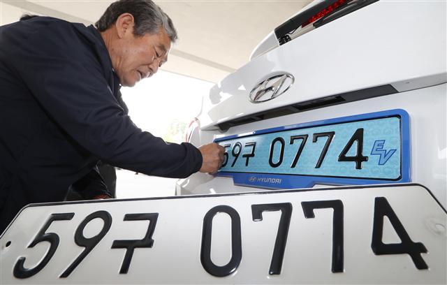 <YONHAP PHOTO-2197> 전기차 번호판은 '연한 청색'입니다 (세종=연합뉴스) 이진욱 기자 = 8일 정부세종청사 국토교통부 앞에서 직원들이 전기자동차에 전용 번호판을 부착하고 있다. 국토교통부는 전기차 전용 번호판 부착에 관한 내용을 담은 '자동차 등록번호판 등의 기준'을 지난 3월 고시했다. 2017.6.8 cityboy@yna.co.kr/2017-06-08 11:00:11/ <저작권자 ⓒ 1980-2017 ㈜연합뉴스. 무단 전재 재배포 금지.>