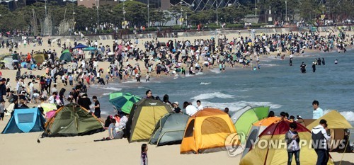 Beachgoers crowd Haeundae Beach in the southeastern port city of Busan with some pitching tents to avoid the heat on May 3, 2017. (Yonhap)