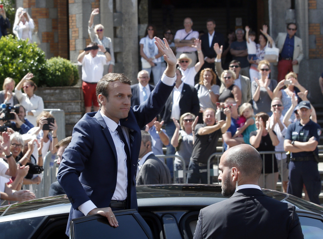 French President Emmanuel Macron waves to the audience as he leaves a polling station in Le Touquet, northern France, after casting his vote in the first round of the two-stage legislative elections, Sunday, June 11, 2017. (AP-Yonhap)