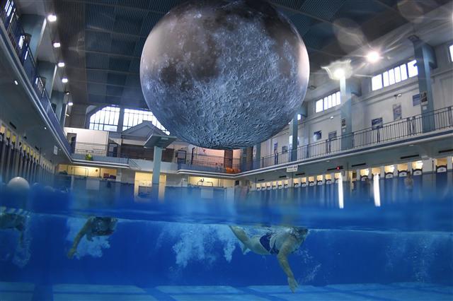 <YONHAP PHOTO-4582> People swim under an artwork 'Museum of the Moon' by British artist Luke Jerram at the Saint-Georges swimming pool in Rennes, western France on June 12, 2017. / AFP PHOTO / DAMIEN MEYER / RESTRICTED TO EDITORIAL USE - MANDATORY MENTION OF THE ARTIST UPON PUBLICATION - TO ILLUSTRATE THE EVENT AS SPECIFIED IN THE CAPTION/2017-06-13 17:51:51/ <저작권자 ⓒ 1980-2017 ㈜연합뉴스. 무단 전재 재배포 금지.>