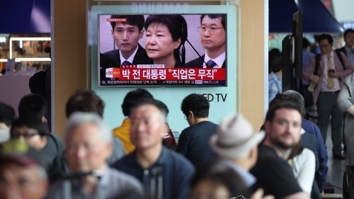 Citizens watch TV news on former President Park Geun-hye's court hearing at Seoul Station in central Seoul on May 23, 2017. (Yonhap)