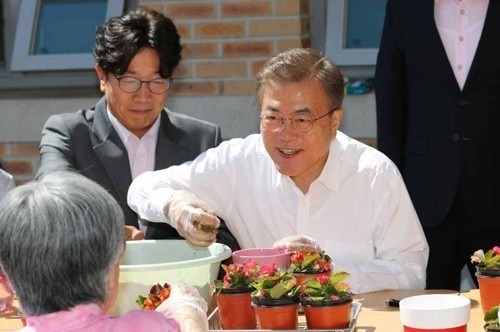 President Moon Jae-in makes pots of flowers with senior citizens at a state-operated nursing home in Seoul on June 2, 2017. (Yonhap)